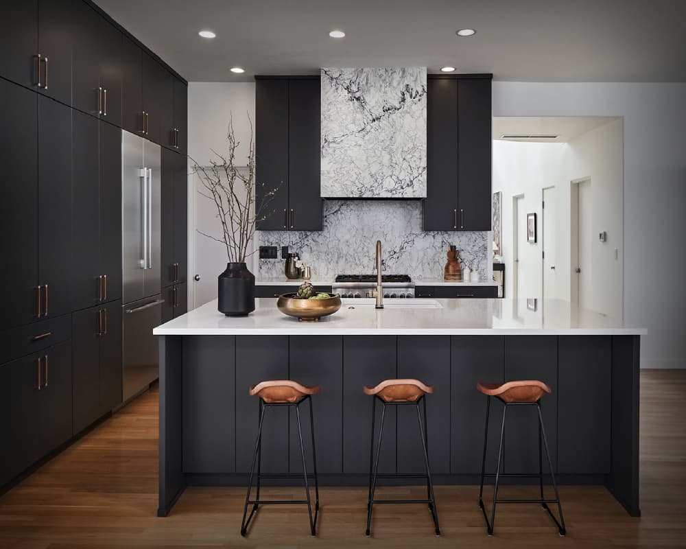A luxurious modern kitchen with marble countertops and sleek cabinetry.